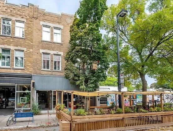 1675 Laurier Est: buff brick building with ground-floor retail and a summer terrasse on the sidewalk