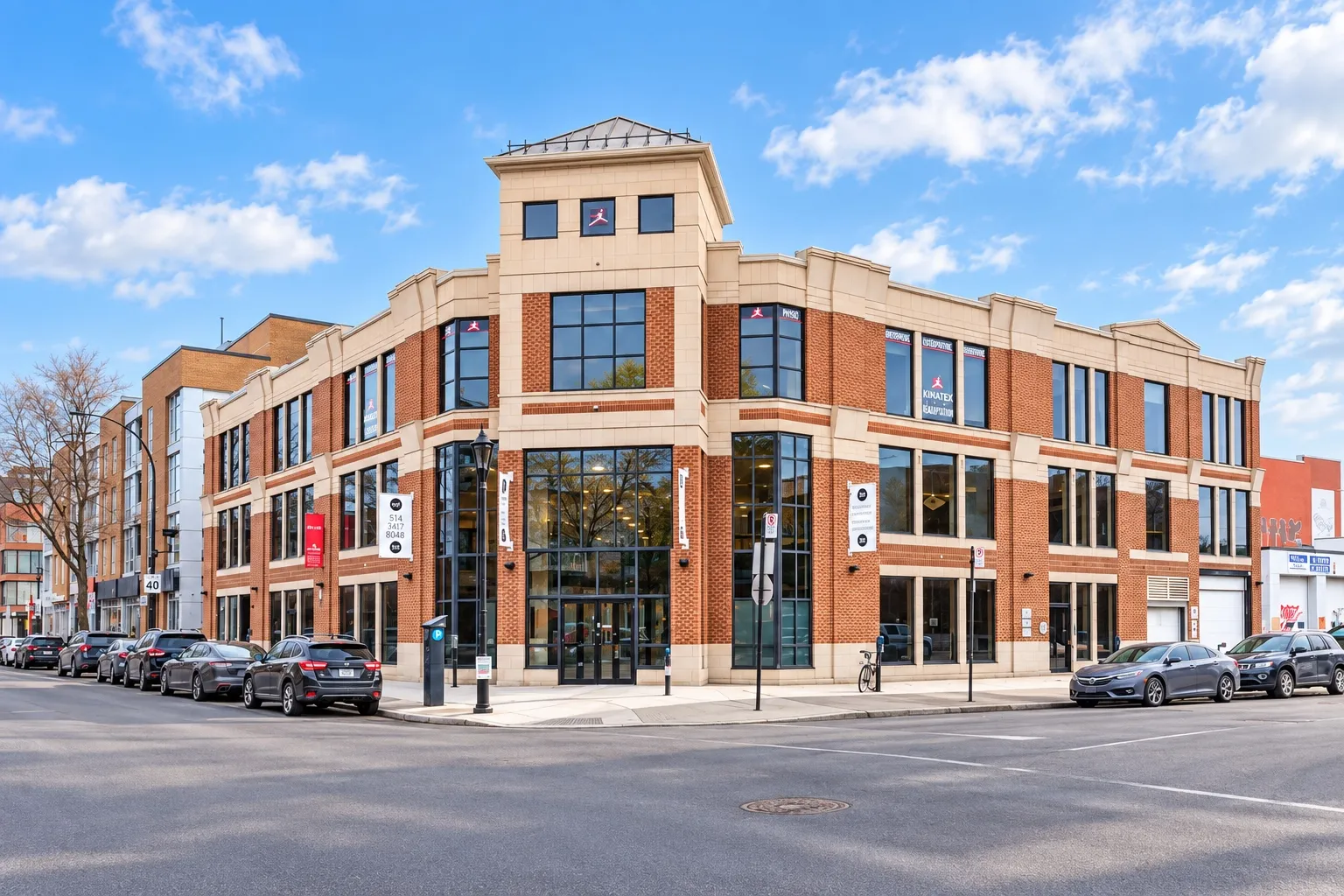 7001 Saint-Laurent: three-storey brick and limestone corner building topped by a stone tower, with clinic and office signage at street level